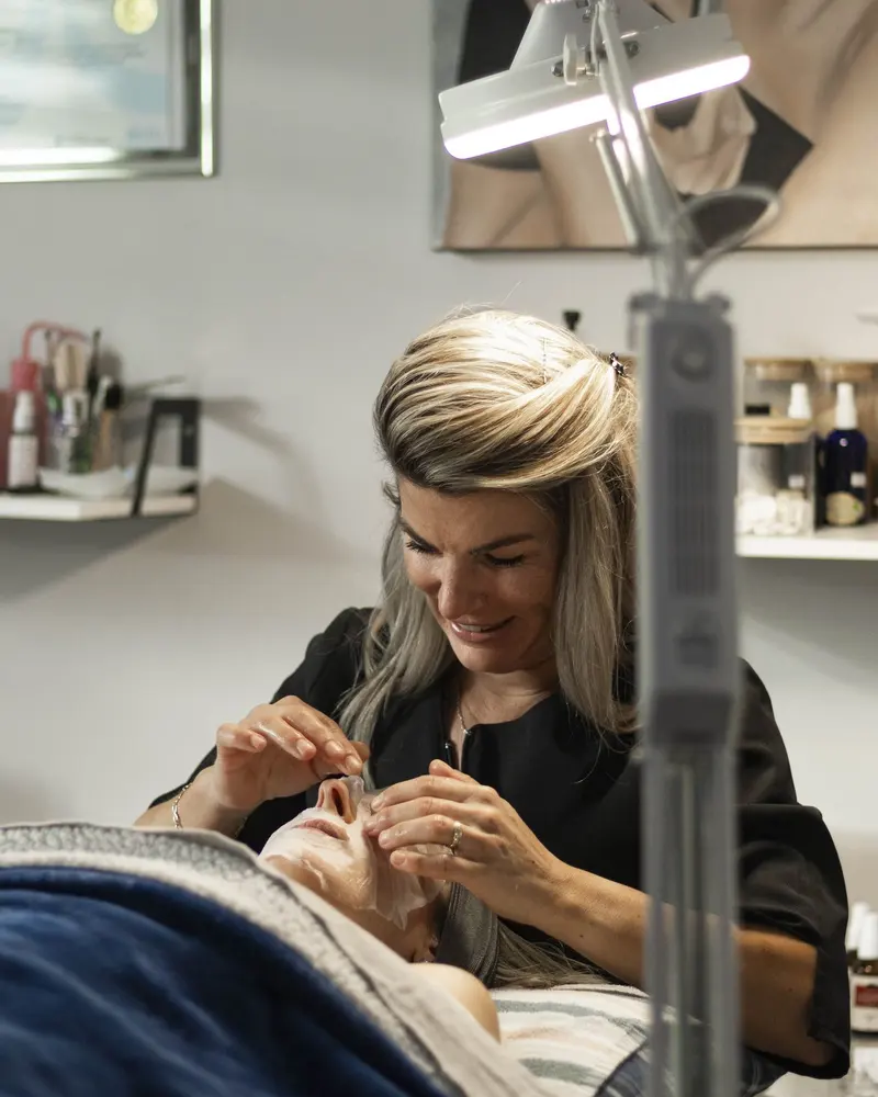 Stéphanie concentrée pendant un soin, dans son salon